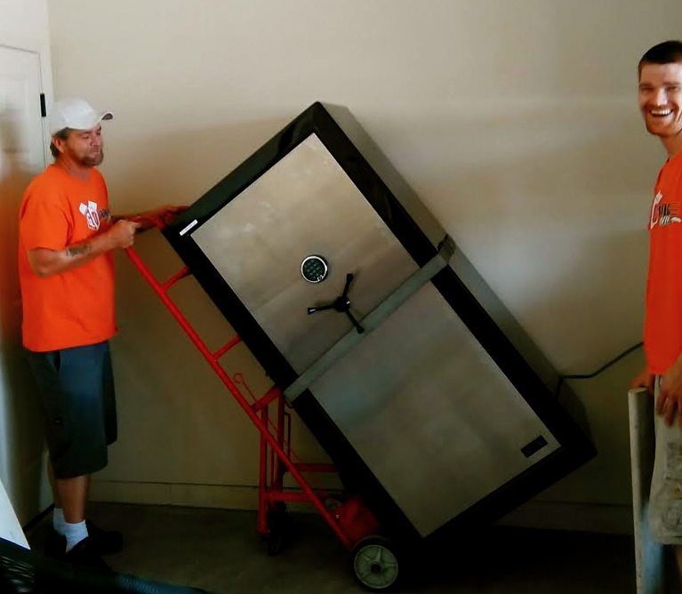 A man moving a refrigerator on a dolly.